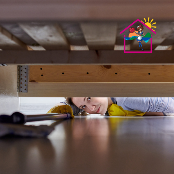 Women laying down reaching under the bed with deep cleaning equipment